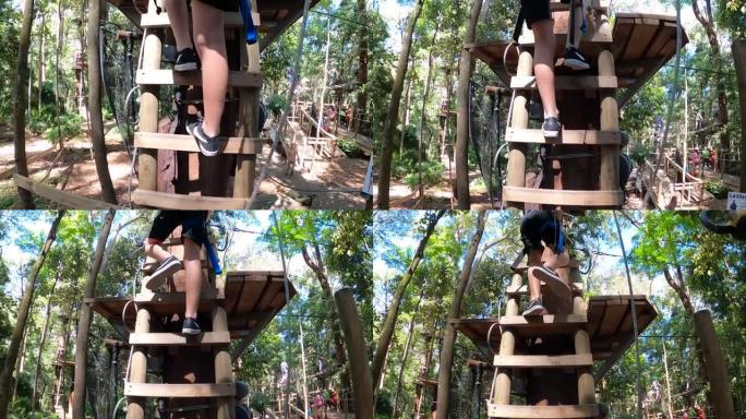 在澳大利亚热带雨林的滑索冒险公园，一个男孩爬上梯子到木制平台。