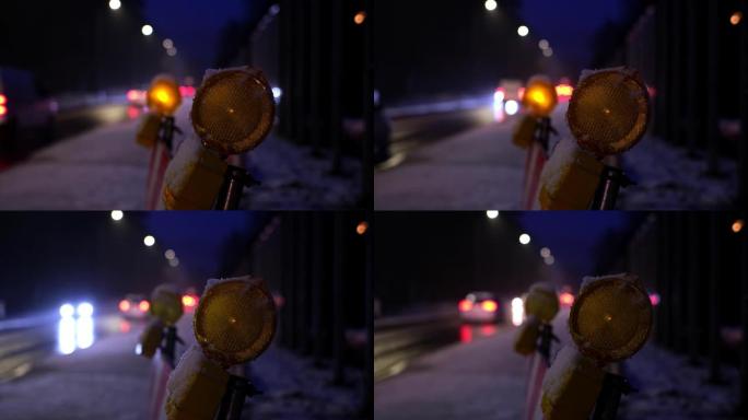 冬季晚上交通拥挤的繁忙结冰道路上，维修道路屏障橙色警示灯依次闪烁