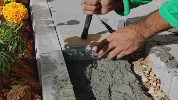 梅森在混凝土混合物上放置水泥砖