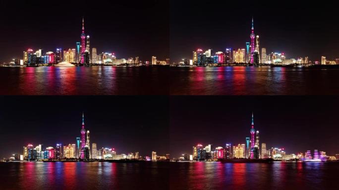 晚上从外滩观看上海天际线，摩天大楼和地标，船只在黄浦江上航行，延时4k镜头b滚动拍摄。