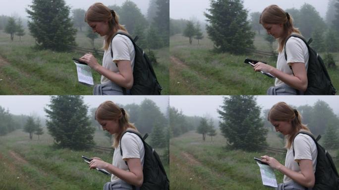 带着地图和智能手机设备的年轻女孩游客正在寻找通往山顶的路径方向