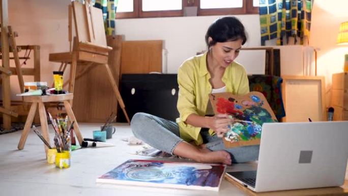 女艺术家在现代艺术工作室的笔记本电脑上录制自己的DIY教程