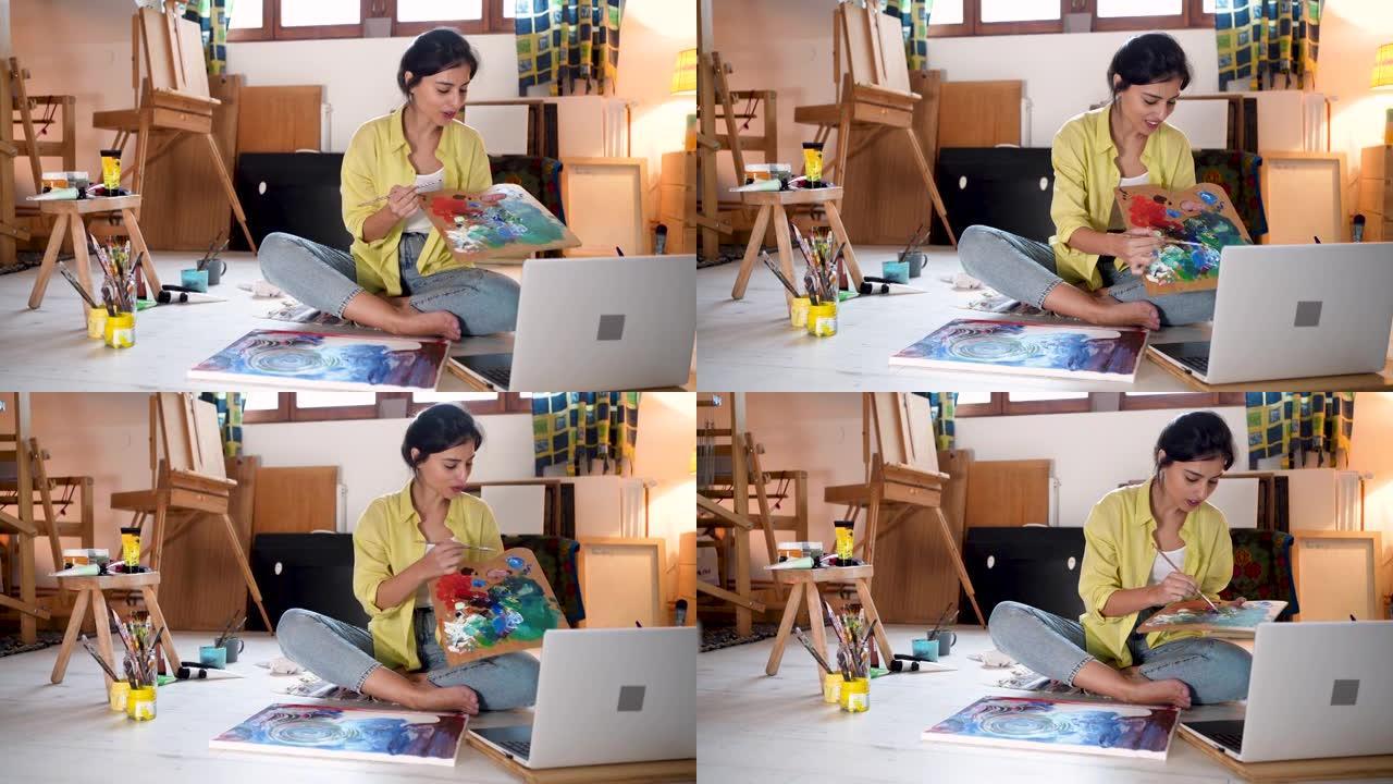 女艺术家在现代艺术工作室的笔记本电脑上录制自己的DIY教程
