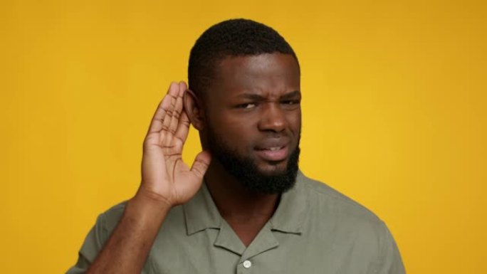 好奇的非洲裔美国人将手放在耳朵附近，试图偷听信息