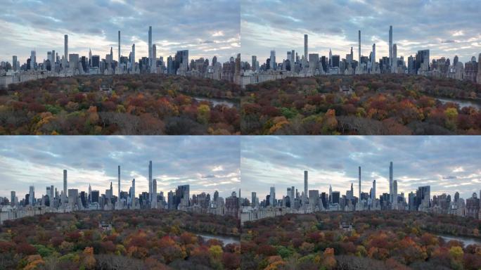 在多云的天空下，市区高层建筑的全景。中央公园里的彩树。美国纽约市曼哈顿