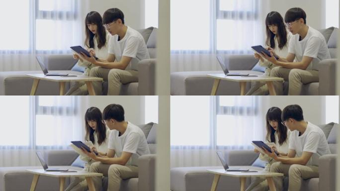 亚洲年轻夫妇用笔记本电脑计算费用财务，并在家里一起讨论计划