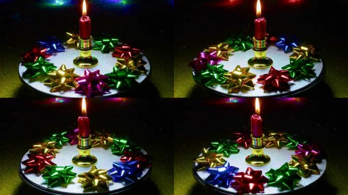 运动中的圣诞节带有装饰的燃烧蜡烛在带有灯泡的背景上旋转