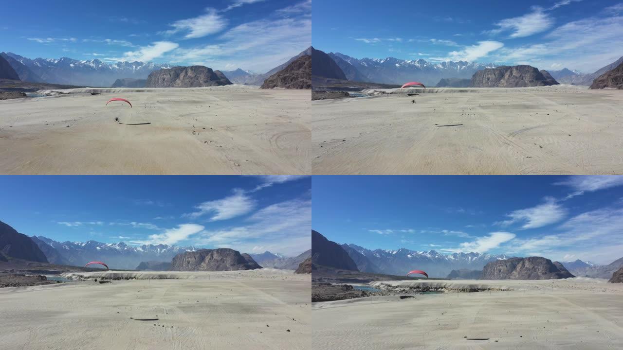 在巴基斯坦北部的Katpana沙漠上空飞行的paramotor的风景鸟瞰图