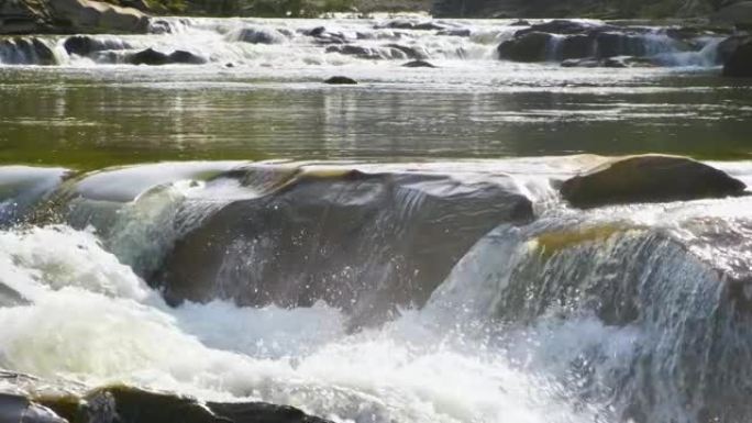 山河，清澈的绿松石水在湿石块之间的梯级中落下，白色泡沫浓厚