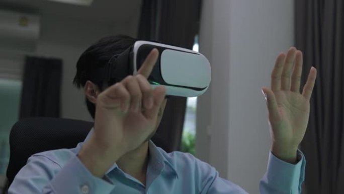 带虚拟现实眼镜的亚洲男子耳机在家中触摸空气