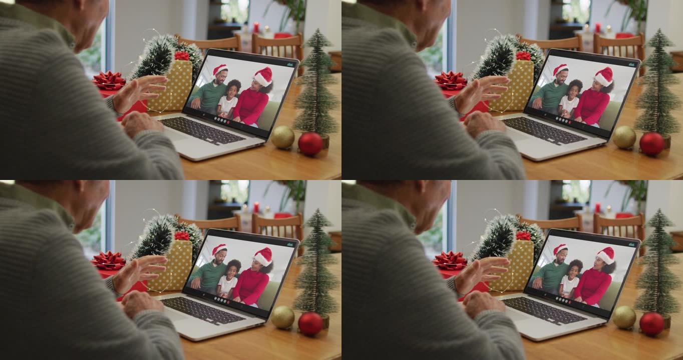 白人高级男子在屏幕上与非裔美国人家庭在笔记本电脑上进行圣诞节视频通话