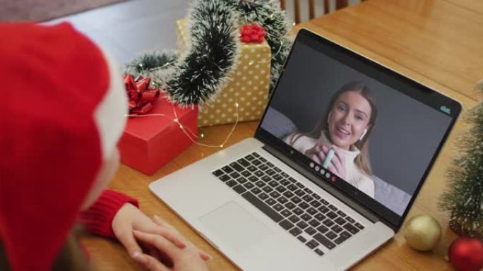 快乐的白人妇女在圣诞节与女性朋友进行视频通话