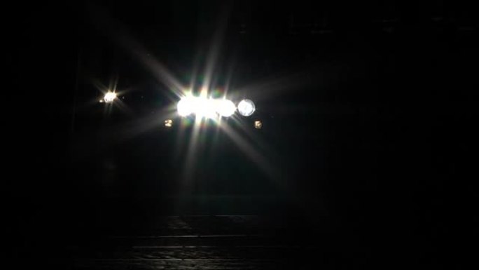 晚上在十字路口停车时，一名男子开着前灯路过汽车前26