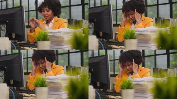 在公司办公室压力下工作的不堪重负的女商人的特写。紧张的上班族坐在办公桌前，深夜加班。