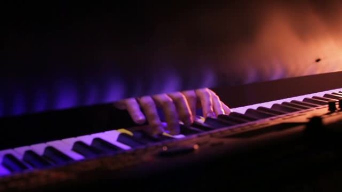 钢琴演奏者的手在夜晚的音乐会上演奏音乐，灯光超赞