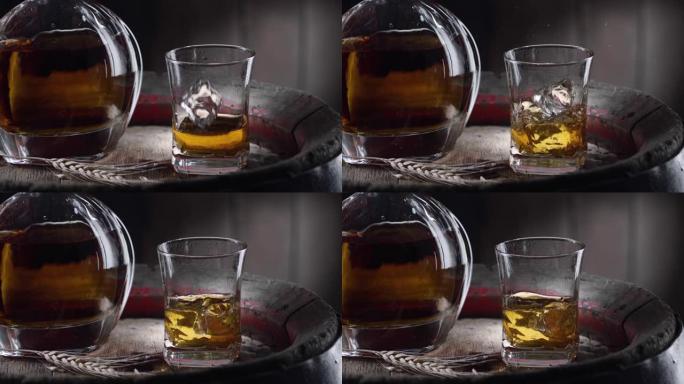 一块冰块慢慢落入老式威士忌桶顶部的一杯威士忌中。附近有一个装有饮料的decanter水器，背景为深棕