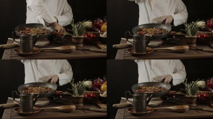 穿着白色制服和帽子的男性厨师将盐和草药放在蔬菜的食物盘子上