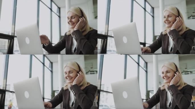 中年商务女性-办公室里戴着耳机的经理，并在线为客户提供建议