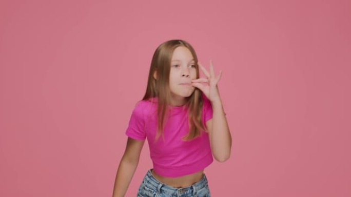 酷的童女表现出沉默的姿态，承诺在粉色工作室背景下保密。隐私概念