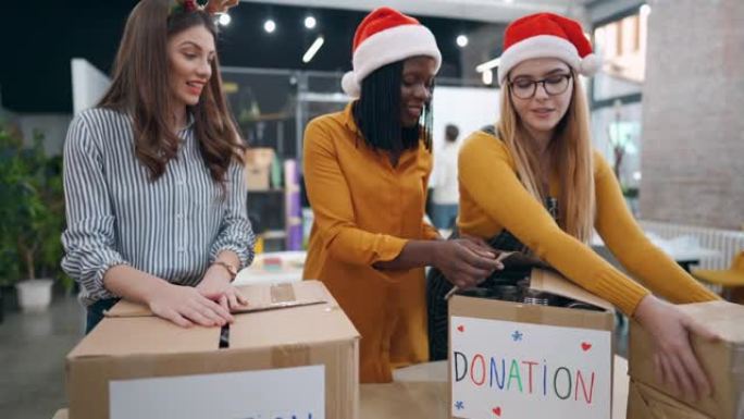 关心多种族女性同事，打包食品罐头，作为圣诞节捐赠给有需要的人