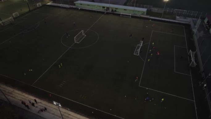 足球运动员在夜间在球场上训练足球