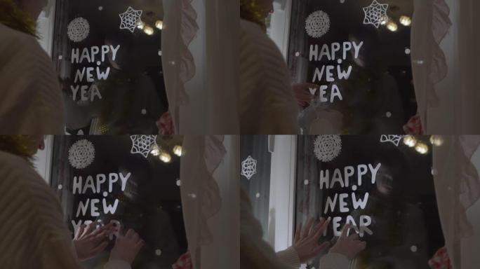 十几岁的女孩用纸字母装饰窗户玻璃新年快乐