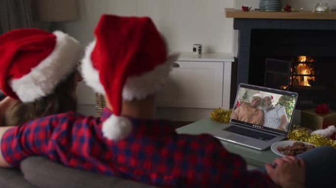 圣诞节时，快乐的高加索夫妇在笔记本电脑上与高级夫妇进行视频通话