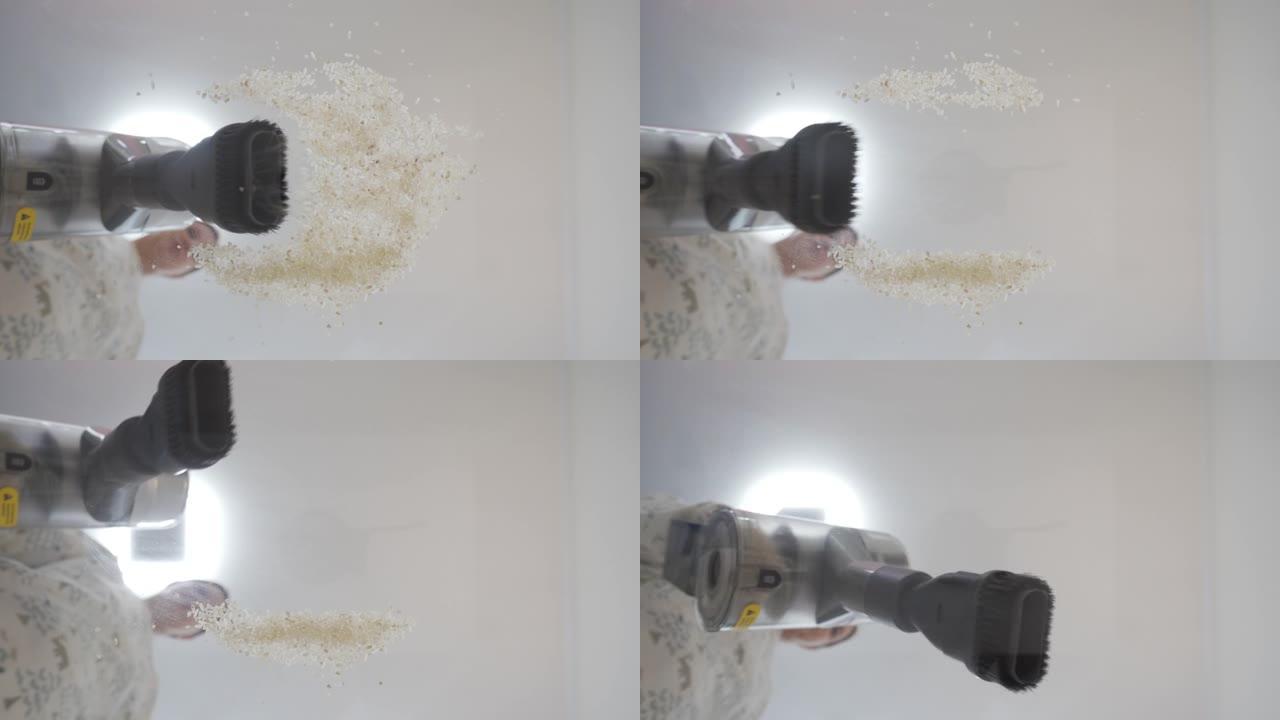 打扫客厅，无绳棒吸尘器的特写镜头从玻璃上吸食米粒。