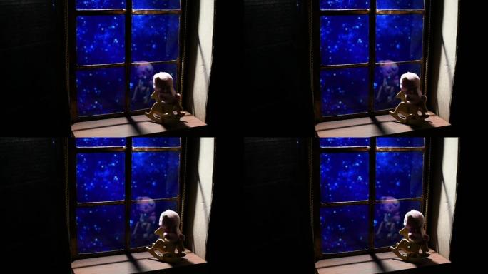 婴儿摇椅上的玩具在夜晚窗外星空的背景下