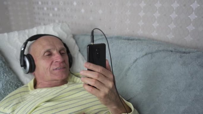 戴着耳机的老人在自我隔离期间与家人进行视频通话。