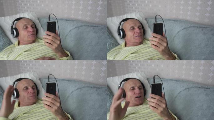 戴着耳机的老人在自我隔离期间与家人进行视频通话。