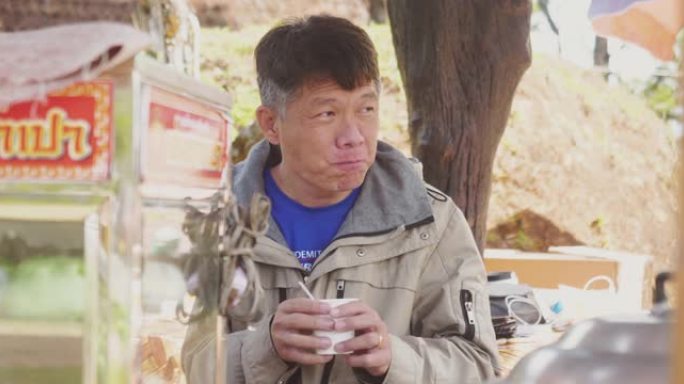 亚洲男子独自背包旅行。男性旅游摄影师休息吃饭
