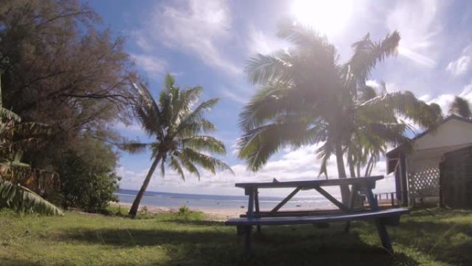 手持海滩边的特写野餐桌仍然可以看到阳光明媚的日子里的海洋，蓝天阳光明媚的阳光椰子树平潮位于南太平洋岛