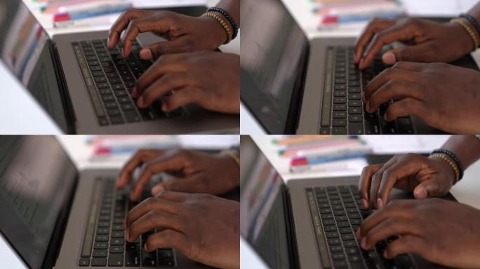 在笔记本电脑键盘上打字的男性手的特写