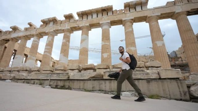 男性游客花时间在雅典古代雅典卫城的柱子上行走