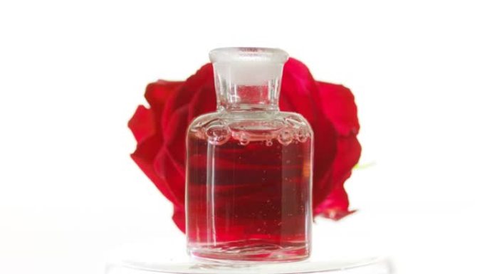 玫瑰油倒入瓶中，在玫瑰前产生气泡