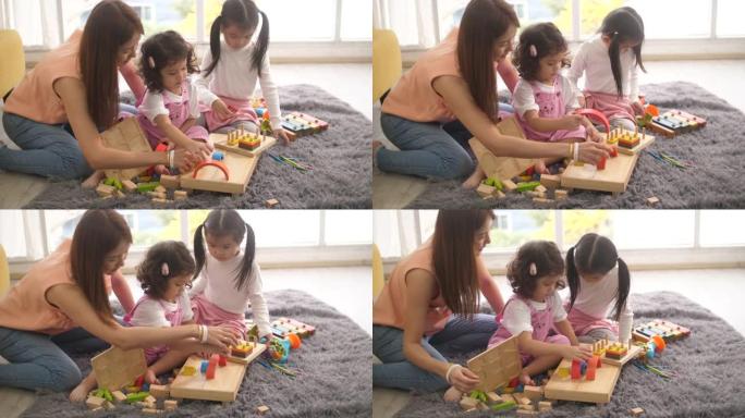 亚洲妇女从周末工作中休息，看着她的婴儿在客厅里玩玩具，积木
