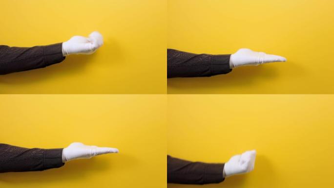 男性穿着白色手套的衬衫的手伸出手并打开它。黄色背景。特写。帮助和指向的概念