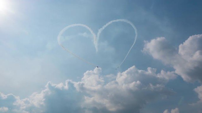 一组三架飞机在多云的天空中充满了特技飞行的心脏形象