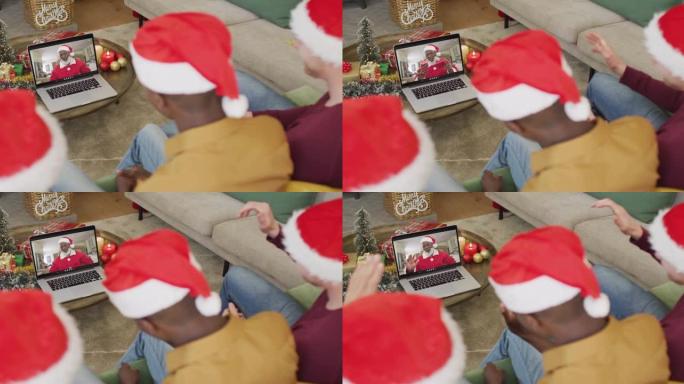 拥有圣诞老人帽子的多元化家庭使用笔记本电脑进行圣诞节视频通话，屏幕上有快乐的圣诞老人