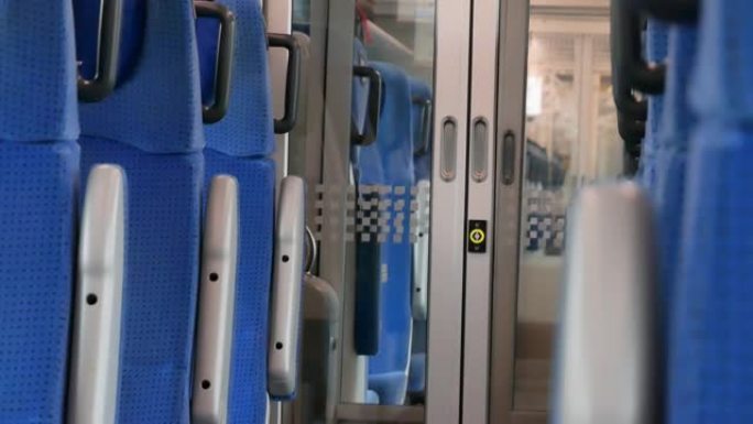 简单的空置现代旅客列车内部，一排排普通的蓝色座椅，空走廊细节，特写镜头，没人。平静放松的场景，里面移