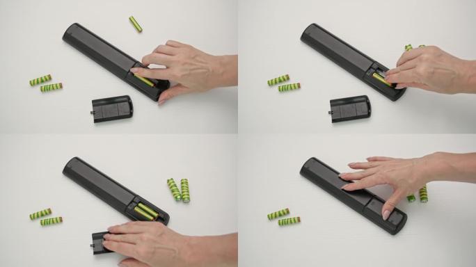 年轻女子将电池放在木制背景上的遥控器中，俯视图