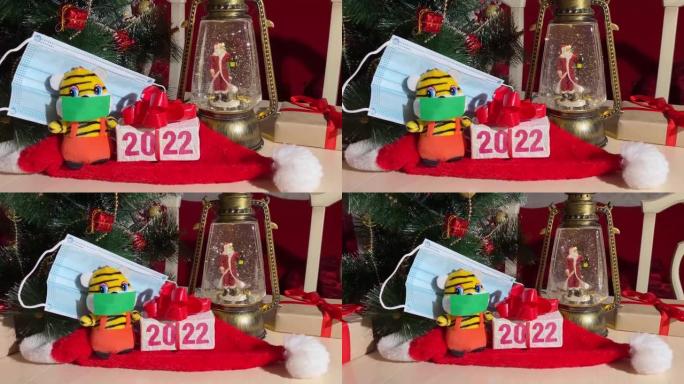 象征2022年新年的老虎带着防护面具，圣诞灯带着圣诞老人和新年树。冠状病毒大流行期间的安全假日庆祝概