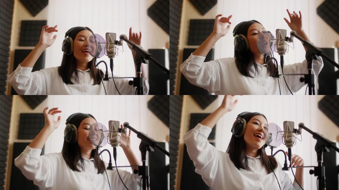 新轨道。精力充沛的亚洲女歌手在音乐工作室录制歌曲