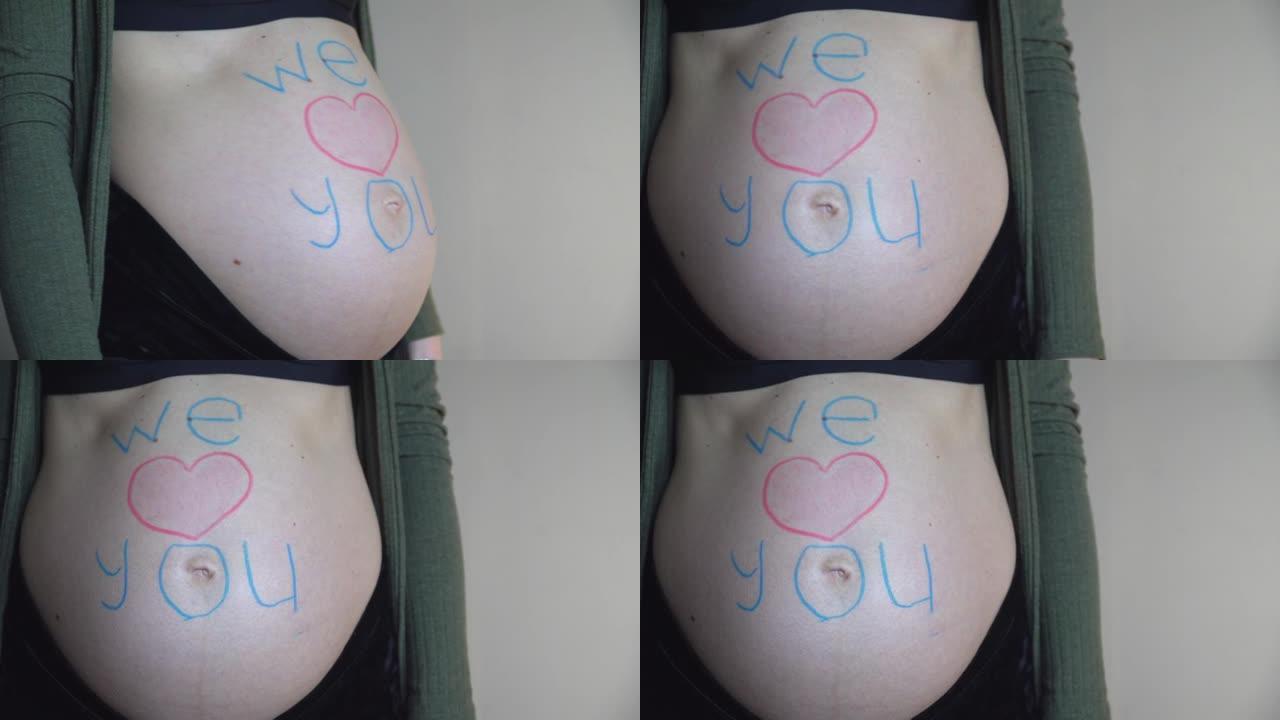 孕妇肚子上有铭文我们爱你。4K。