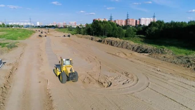 莫斯科郊区沙质建筑工地上的黄色压路机电影