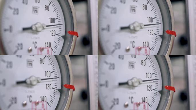 带有刻度盘和箭头的技术温度计的特写镜头。温度计在技术上基于波登管原理，由于加热管的加热而引起的气体膨