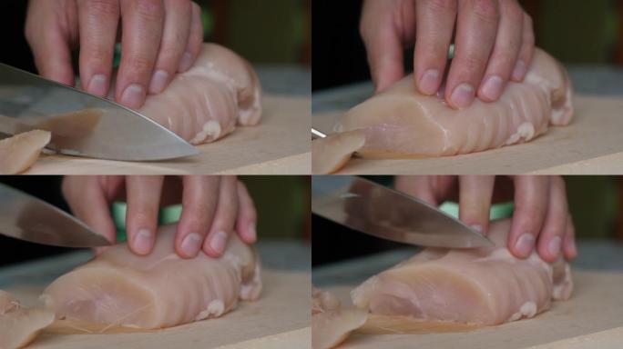 在切好的木板上关闭鸡柳。男人的手刀在木切板上切片精致的火鸡鱼片。厨师切鸡胸肉，生白肉，厨师煮鸡胸肉，