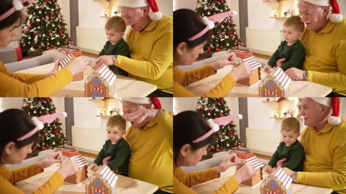 祖父母与孙子一起享受圣诞节的传统，姜饼屋装饰