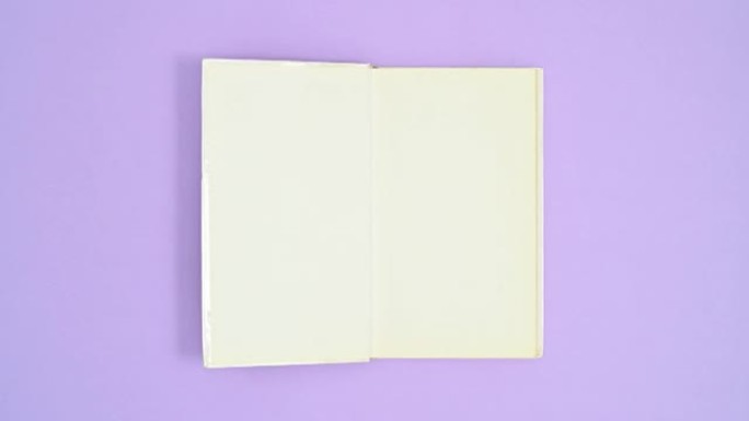 白色精装打开的书以紫色主题出现，关闭并再次打开。停止运动平铺